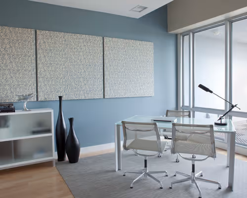 Modern office space with decorative acoustic wall panels and glass furniture, representing commercial noise control solutions.