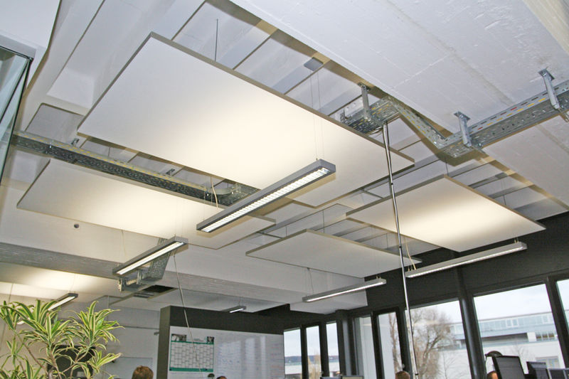 Suspended acoustic ceiling panels in a modern office space, designed to absorb sound and reduce echo in open-plan environments.