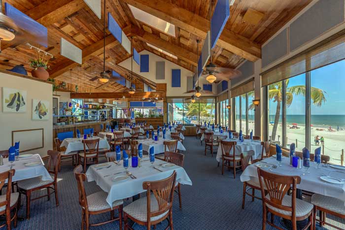 Beachfront restaurant interior with ceiling-mounted acoustic panels to reduce noise and enhance dining experience.