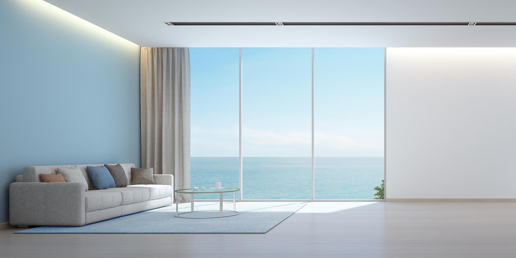 Modern minimalist living room with floor-to-ceiling windows overlooking the ocean, illustrating a quiet, acoustically optimized residential space.