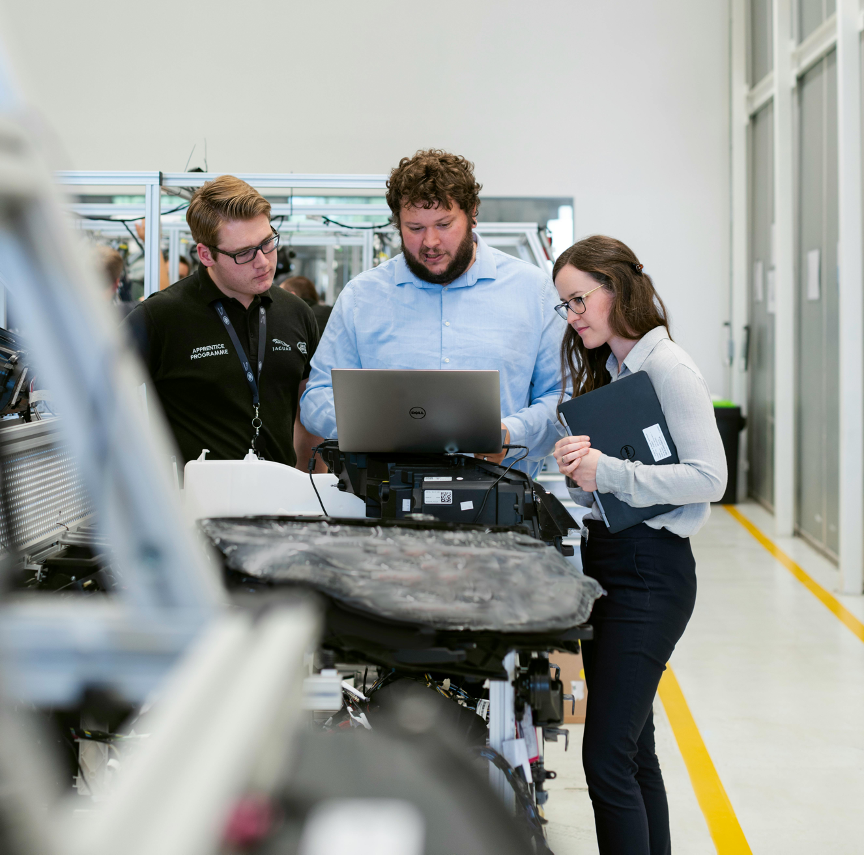 Engineers performing machine runoff testing with diagnostic equipment in a modern manufacturing facility.