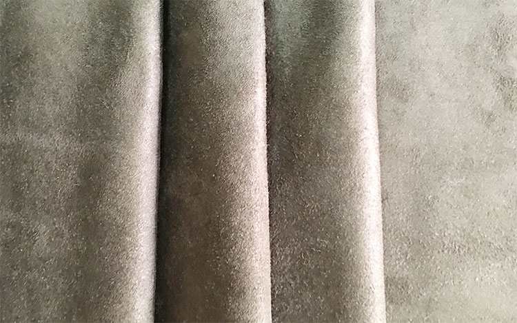 Close-up of soft, beige suede QuietCurtain fabric with visible texture and folds.