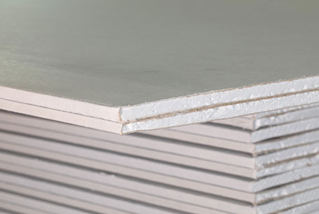 Stack of white drywall panels with a close-up on the edges showing a foam core layer.