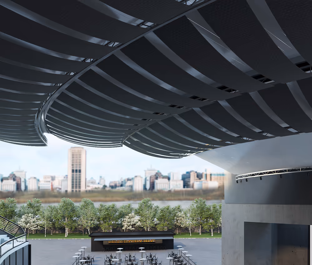 Outdoor seating area with tables and chairs under a large modern curved roof structure with acoustical banners.