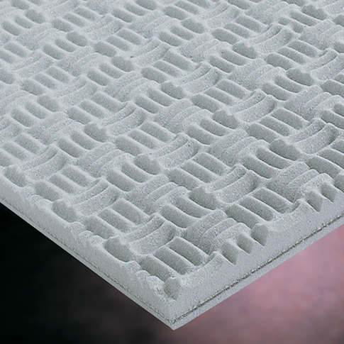 Close-up of a white, textured acoustic panel with interlocking geometric patterns.