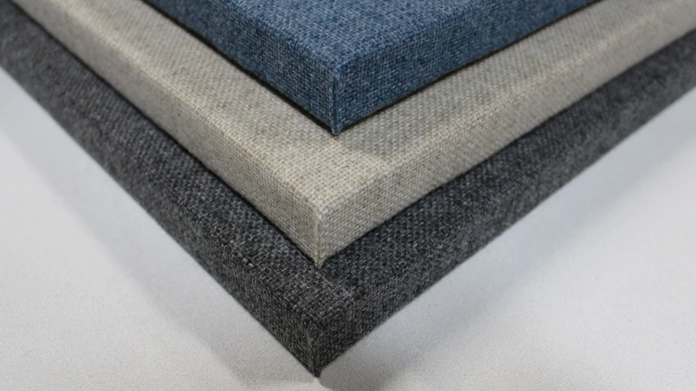 Stack of three rectangular fabric swatches in dark gray, beige, and blue colors.