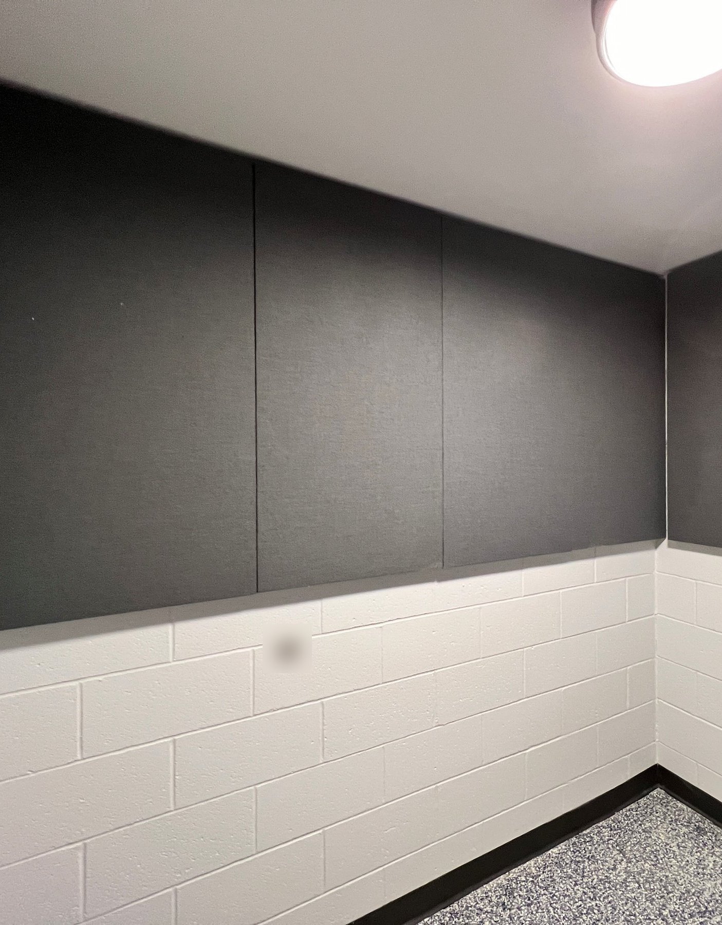 Dark gray fabric-wrapped acoustic panels on the upper walls of an interview room