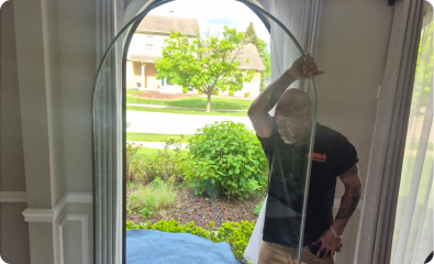 Man holding glass window with curved top