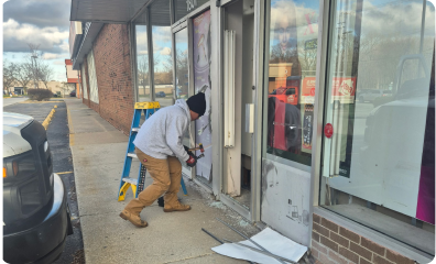 Man fixing business glass window standing on sidewalk