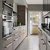 Kitchen remodel in Houston with wooden cabinets, built-in oven, microwave, and a glass door leading to a backyard.