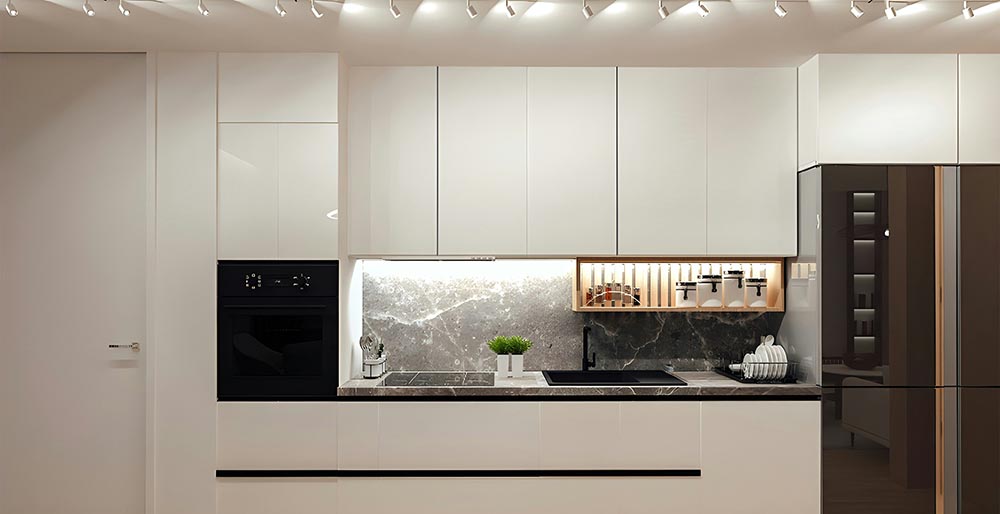 Modern kitchen with white cabinets, black built-in oven, black sink, gray marble backsplash, and under-cabinet lighting.