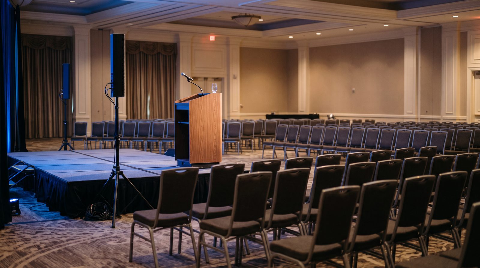 Column array speaker and podium microphone set up in a conference ballroom
