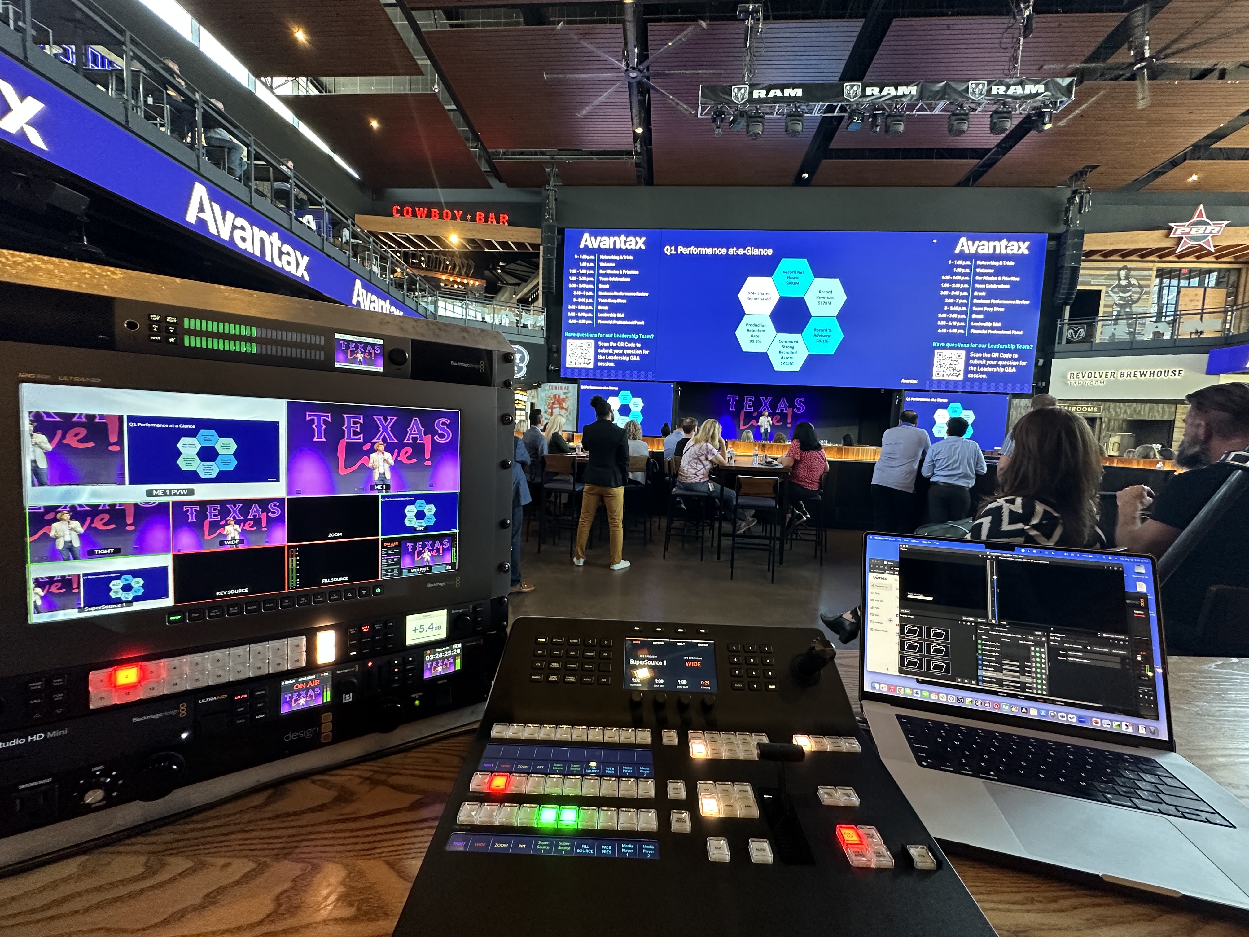 Livestream production setup at a corporate event venue with large LED screens and full production desk