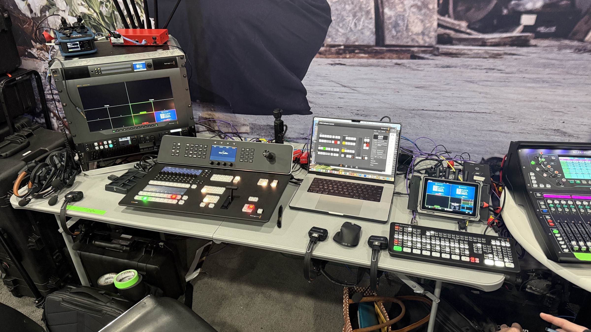 Event live streaming production desk with Blackmagic ATEM switcher, multiview monitor, and Allen & Heath audio mixer set up at a corporate event