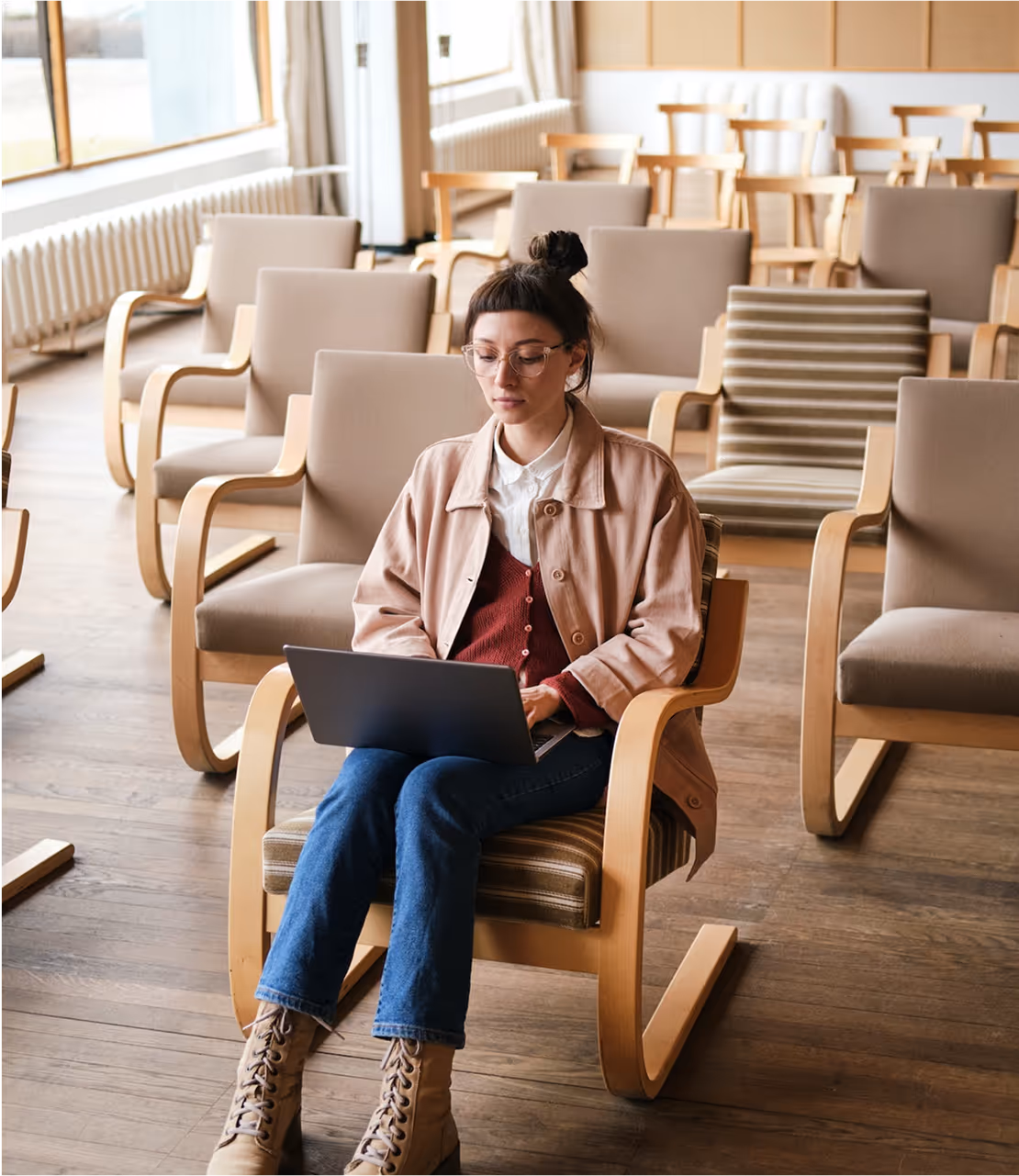 A woman sitting in a chair with a laptop.
