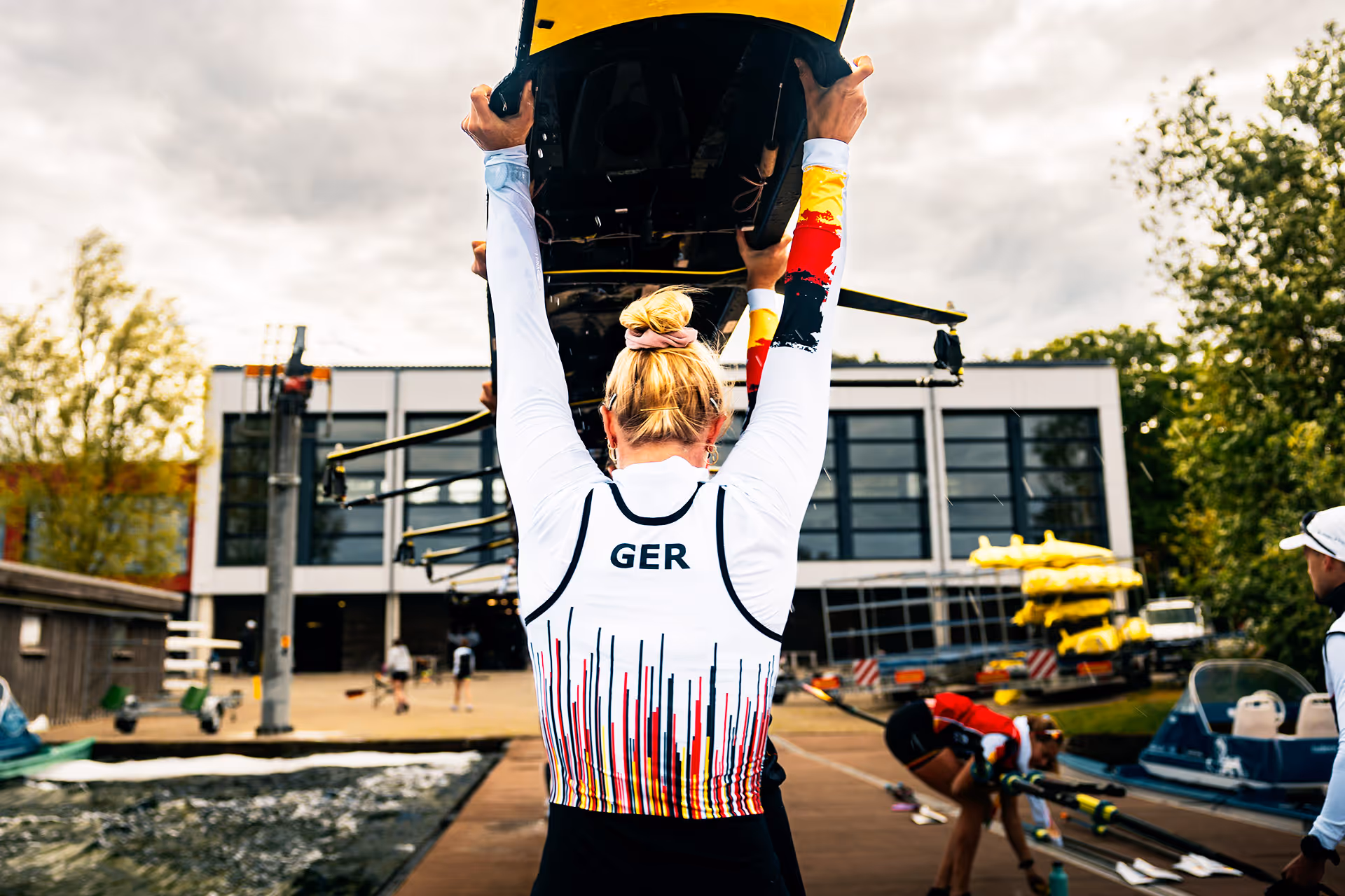 Deutsches Achter-Boot mit Ruderinnen während des Rennens, eingefangen in gleichmäßigem Schlag auf dem Wasser.