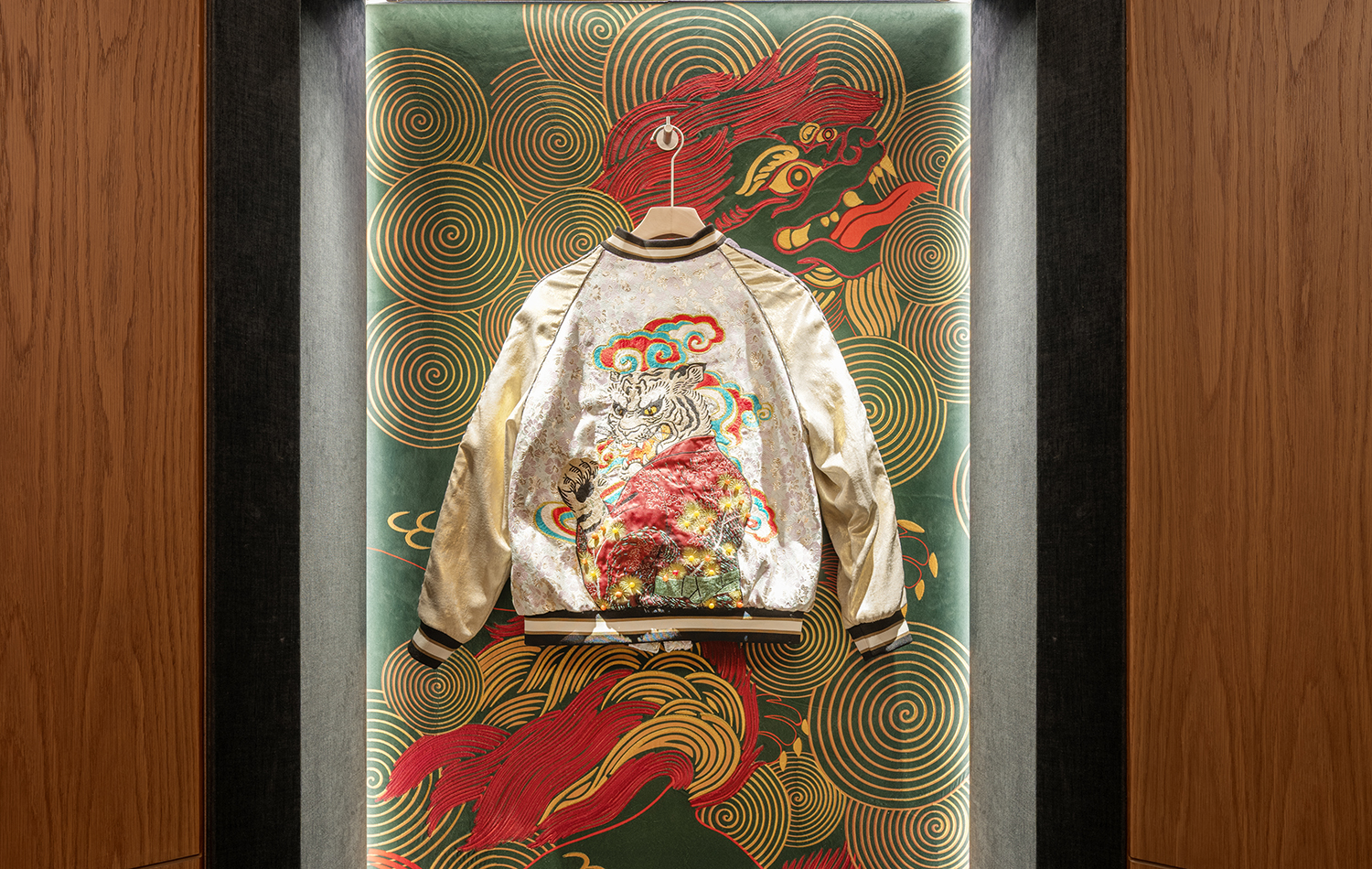 Decorative display at Saikindo listening bar featuring a silk embroidered jacket with Japanese inspired artwork, integrated into the interior design.