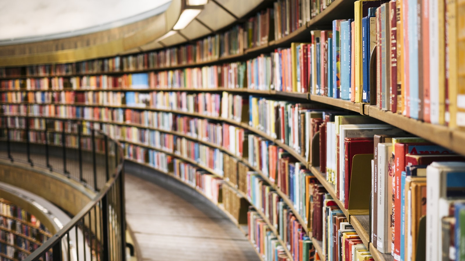 Pile de livres posée sur un bureau à côté d'une paire de lunettes