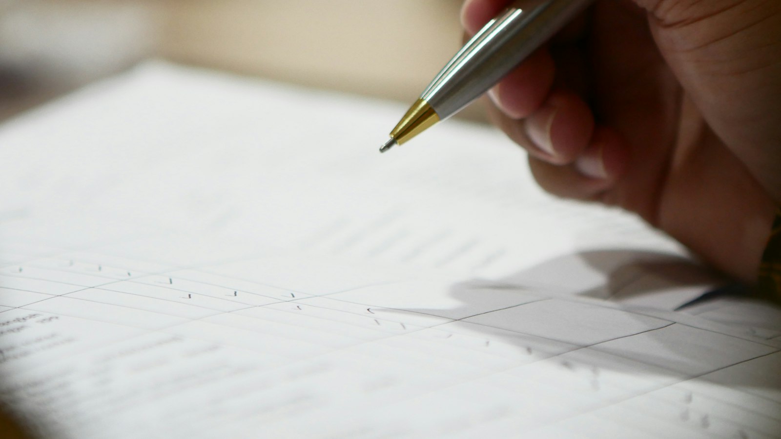 Main tenant un stylo au-dessus d'un document à signer