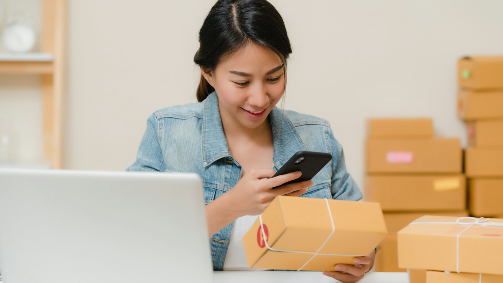 Femme vérifiant un colis avec son téléphone