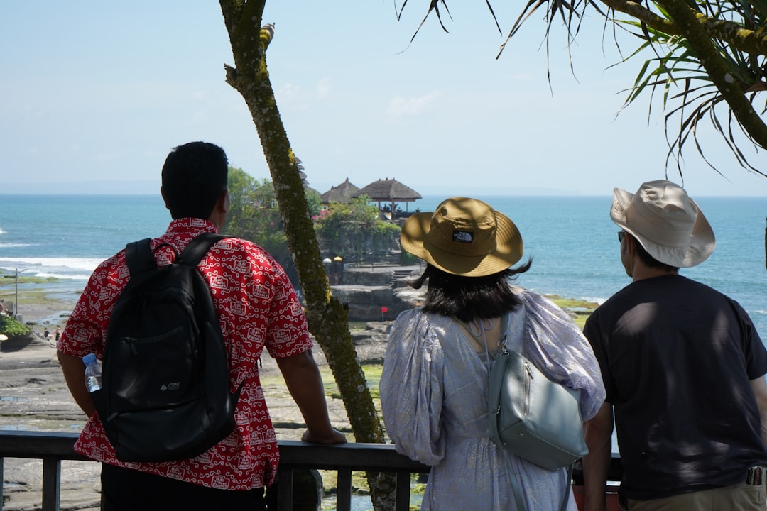 two men and a woman looking out at the ocean