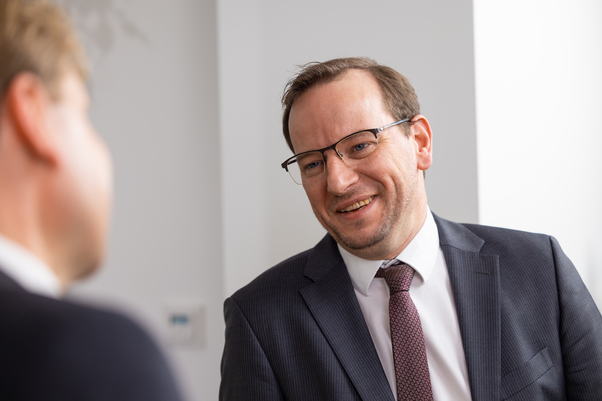 Zwei Männer im Gespräch am, einer unscharf von Hinten zu sehen