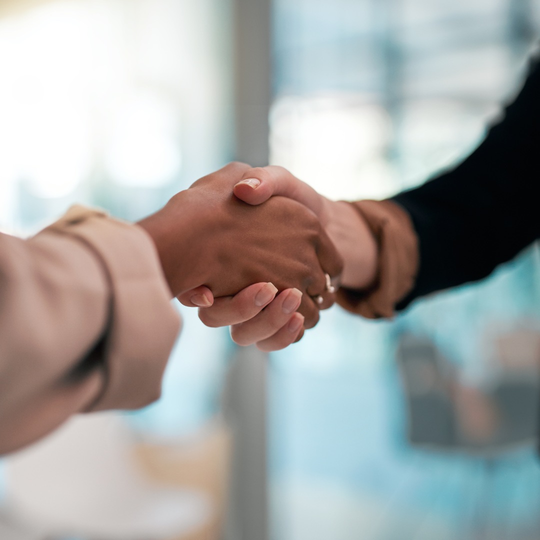 Handschlag im Nahbereich vor unscharfem Hintergrund.
