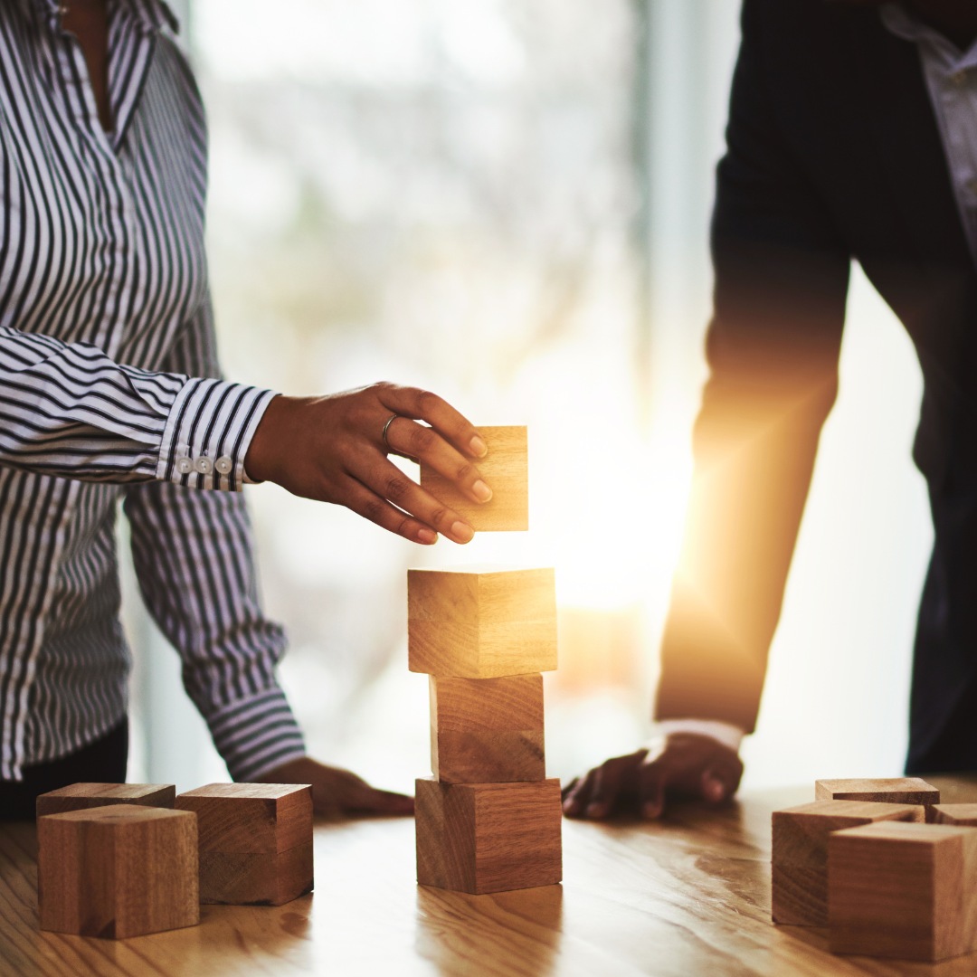 Hände stoßen Gläser im Business-Umfeld an.
