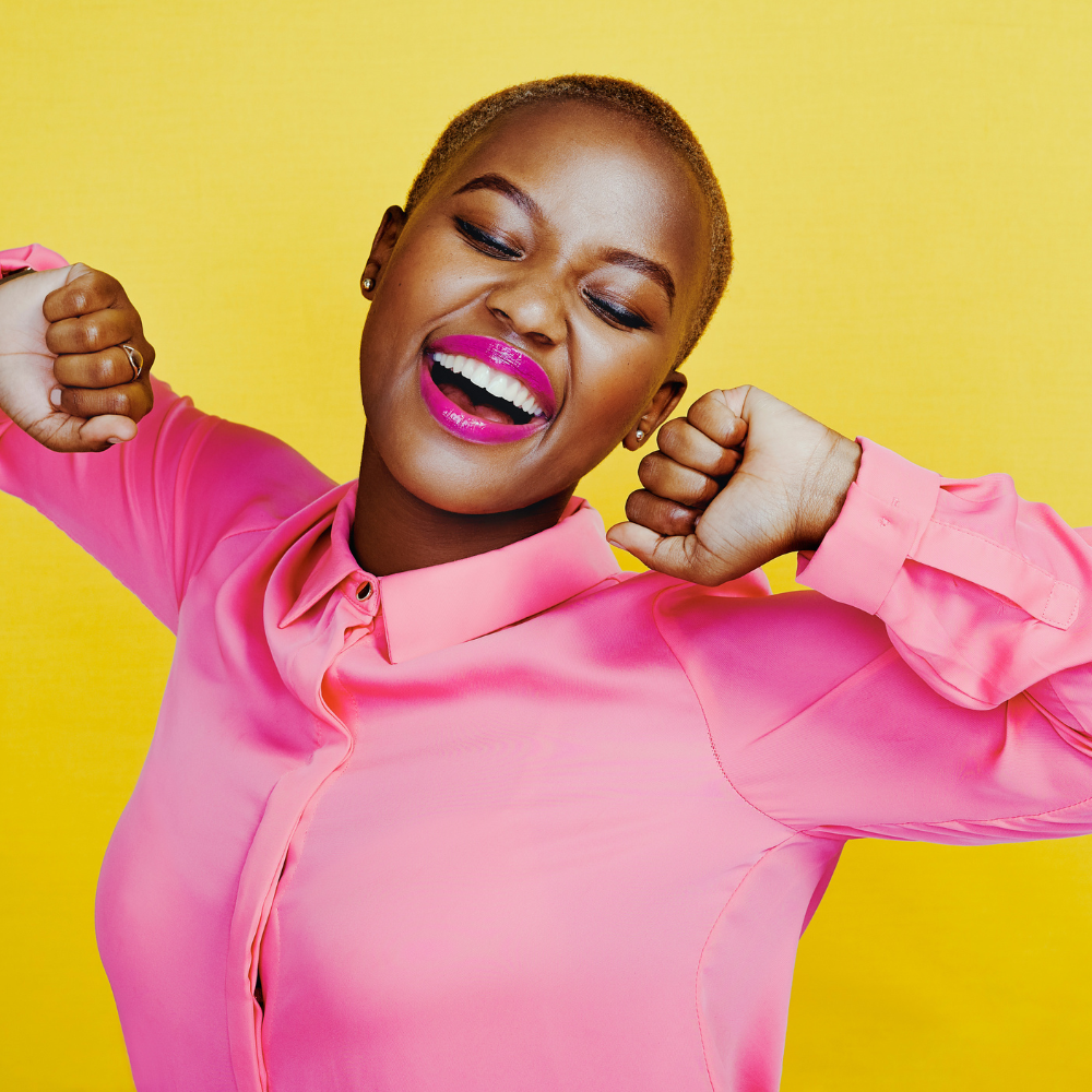 Woman seen in profile laying down on yoga mat in the grass with closed eyes looking serene