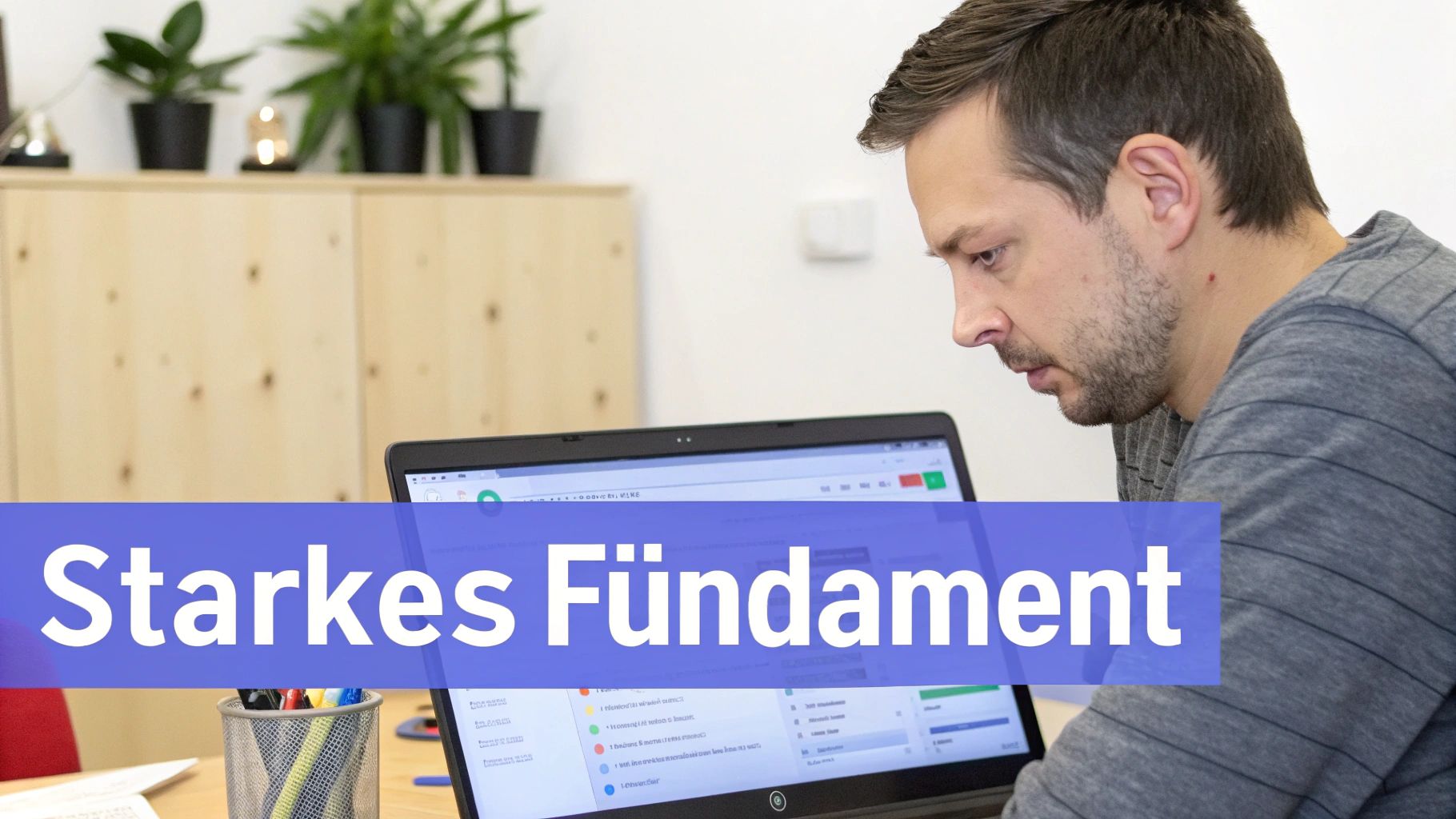 Ein Mann arbeitet konzentriert am Laptop. Die Worte „Starkes Fundament“ sind prominent im Bild platziert.