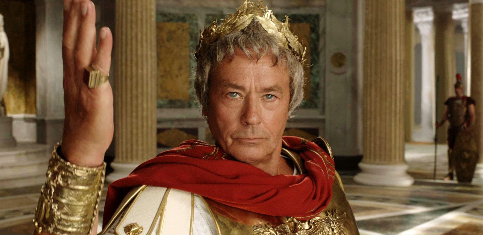 Julius Caesar standing in his palace adorned with gold columns, marble floors, and statues wearing golden crowns and red capes—symbolizing power, victory, and timeless leadership.