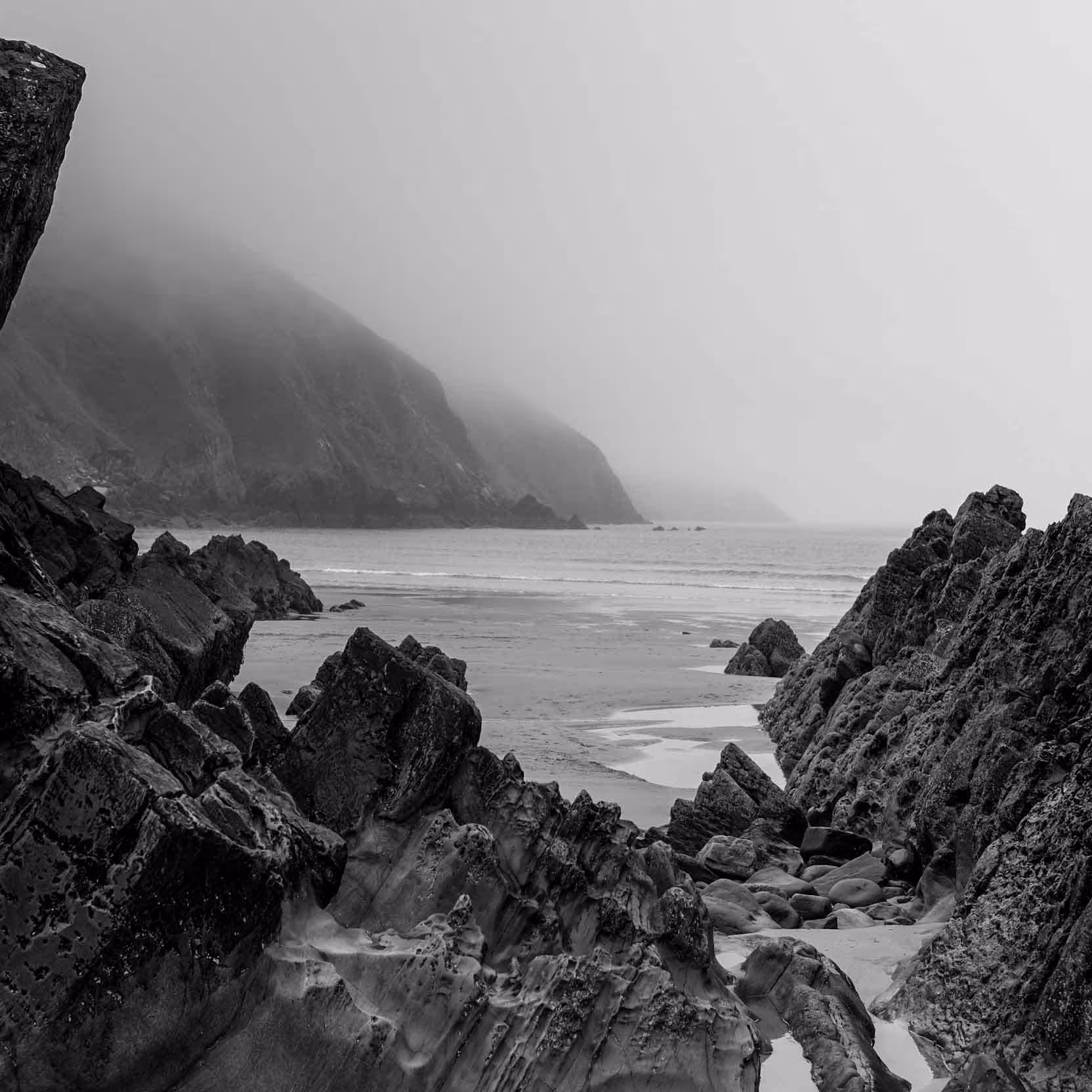 A black and white photo of jagged seas-side rocks at Putsborough beach