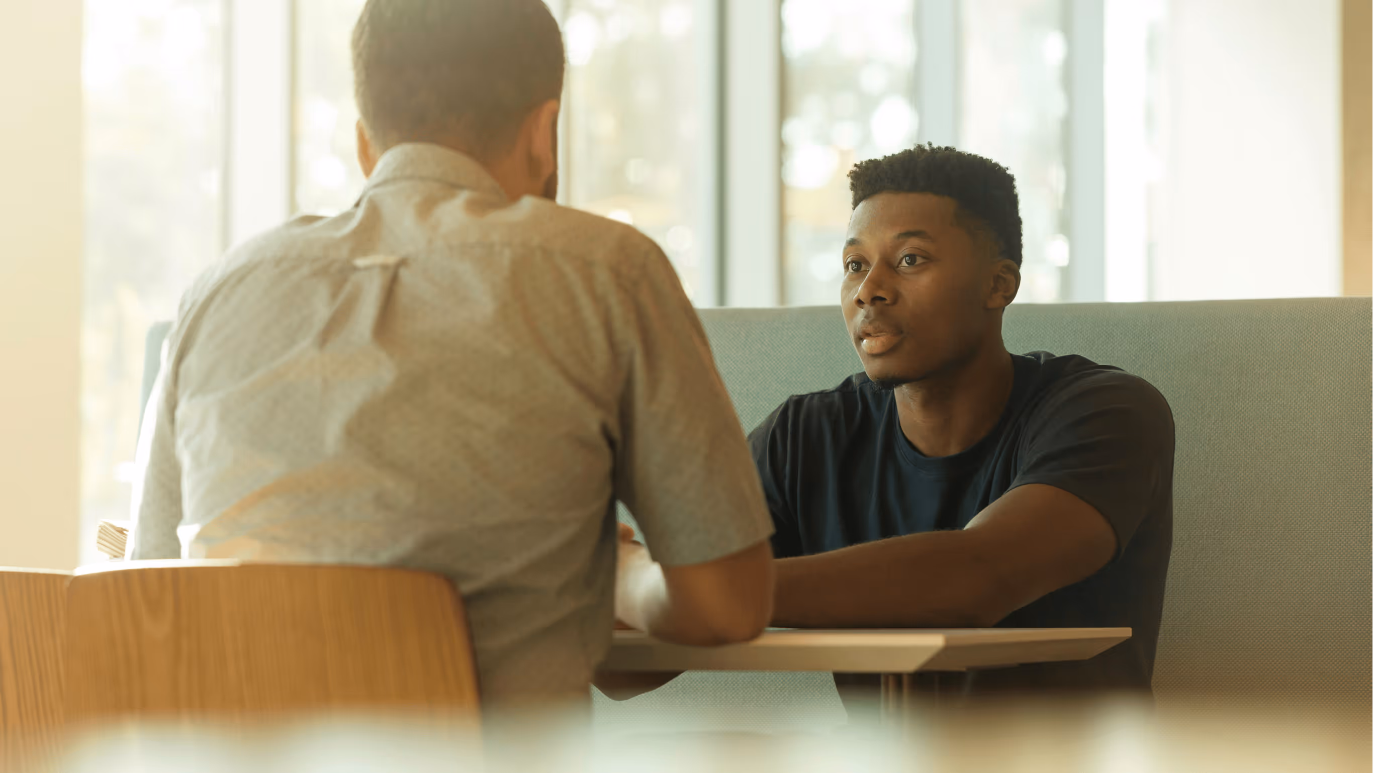 Two people sitting at a table having a serious conversation