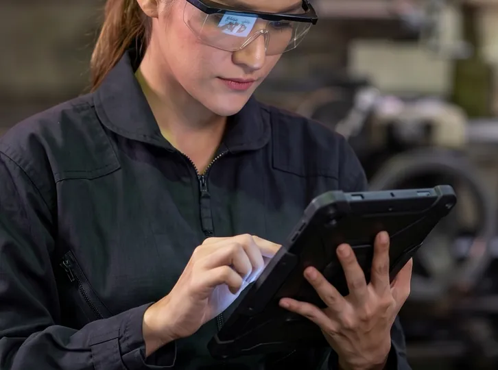 Technician checking production status on a rugged tablet