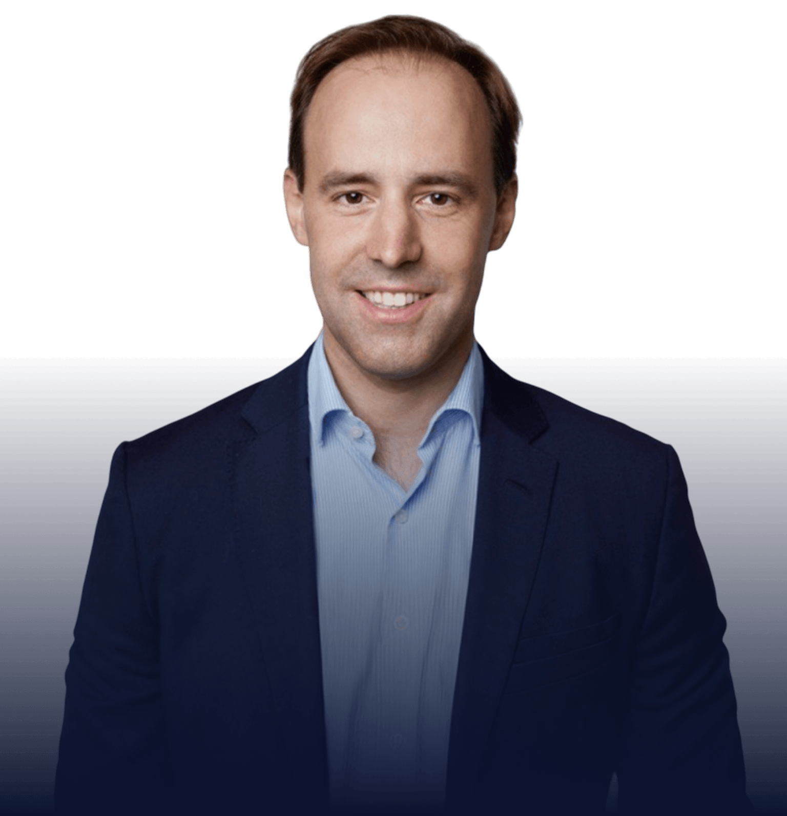 Smiling man with short brown hair wearing a dark blazer and light blue shirt against a dark background.
