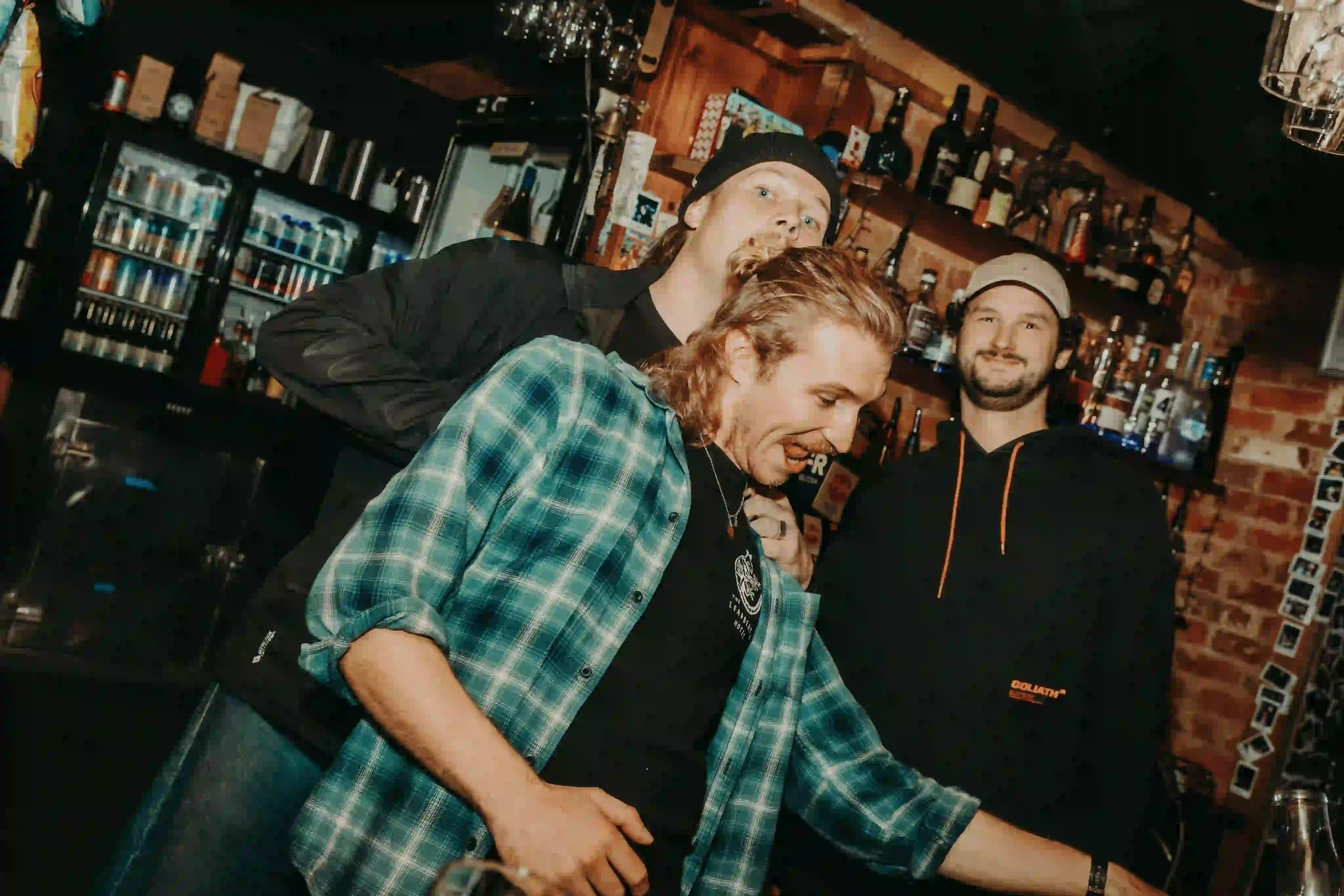 A group of men standing next to each other in a bar.
