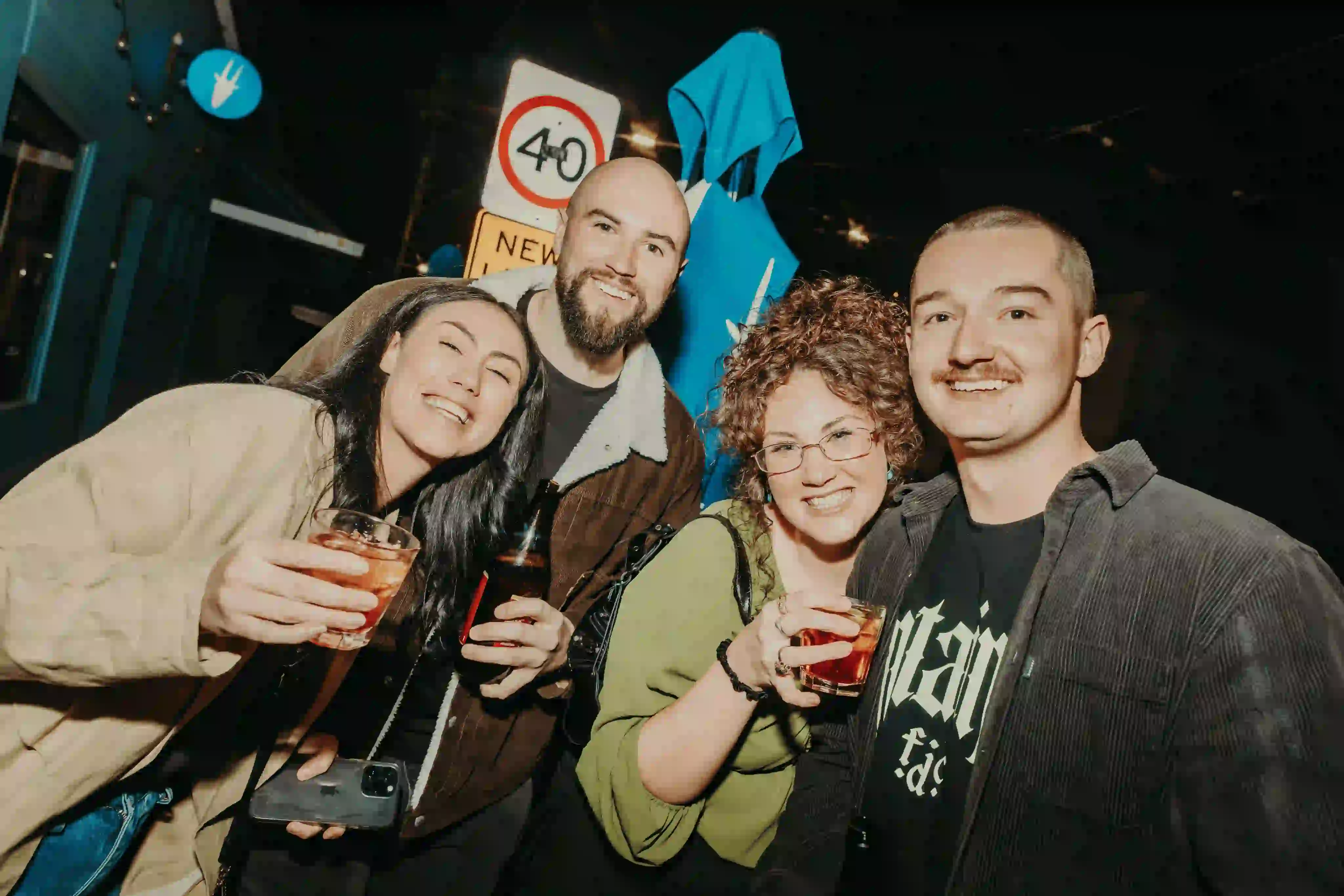 A group of people standing next to each other holding drinks.