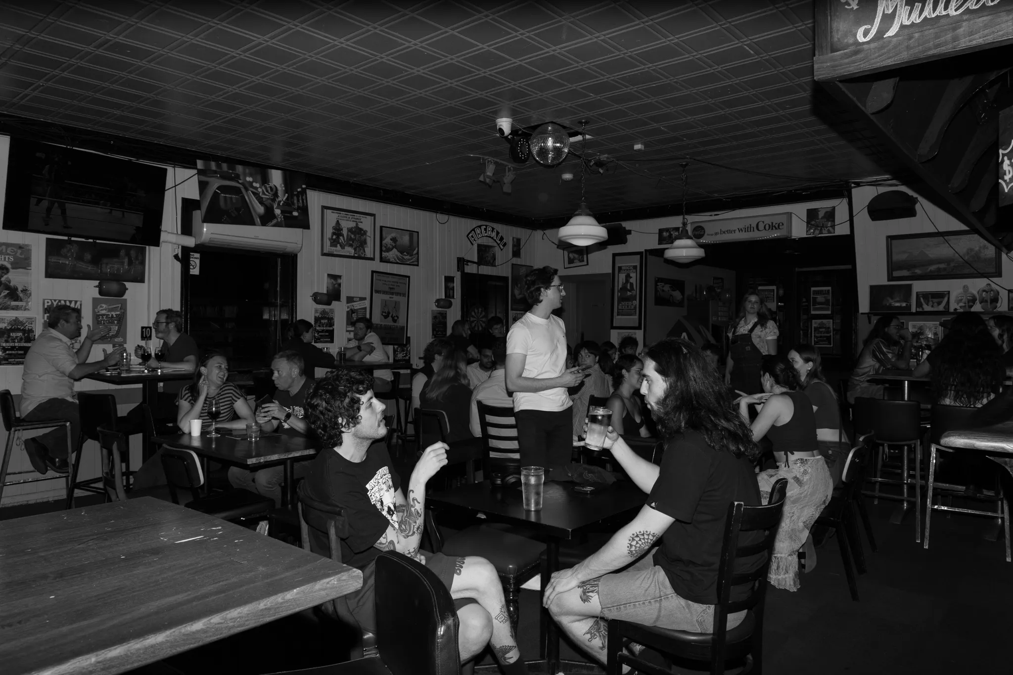 A black and white photo of people sitting in a restaurant.
