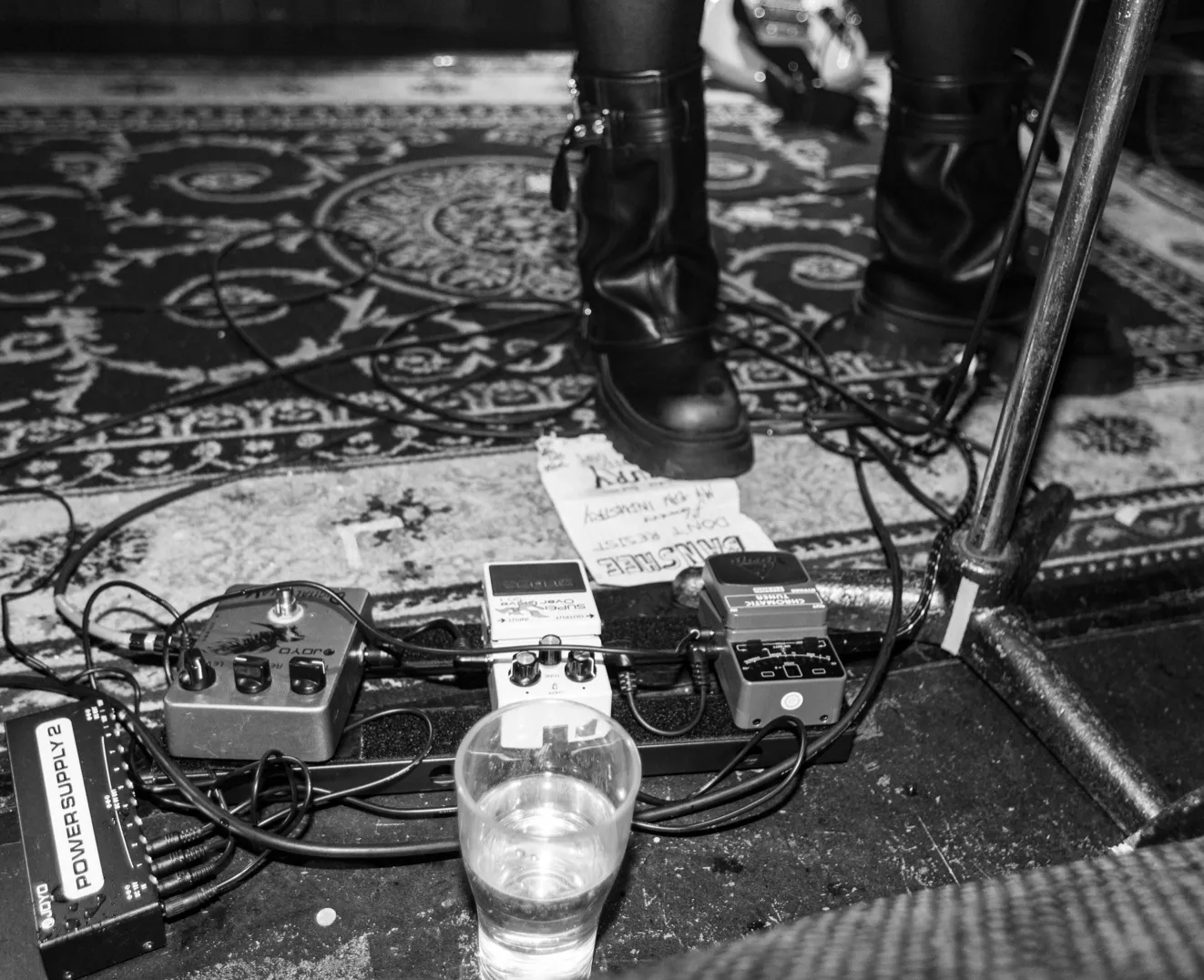 A glass of beer sitting on top of a rug.