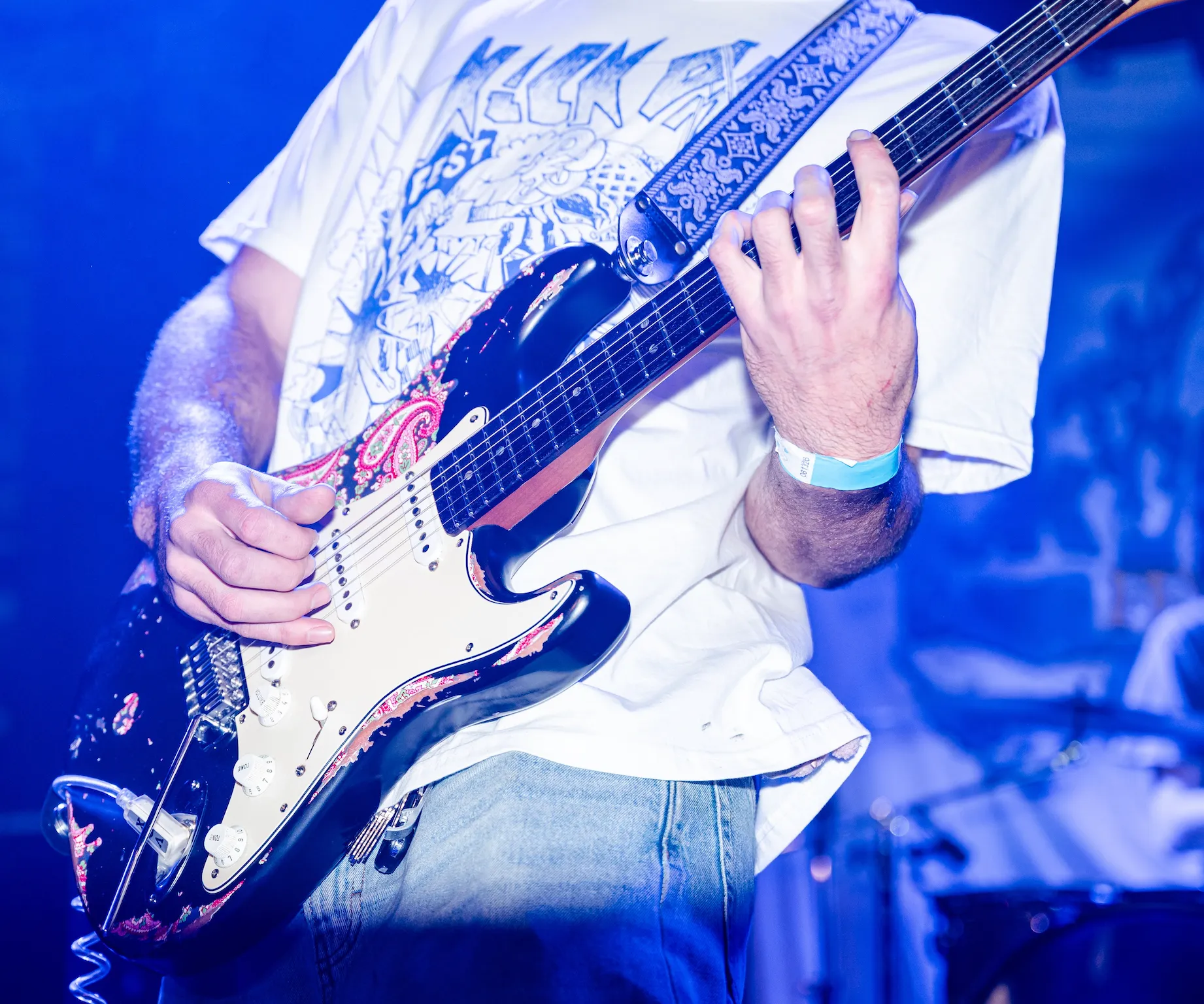 A man playing a guitar on stage at a concert.