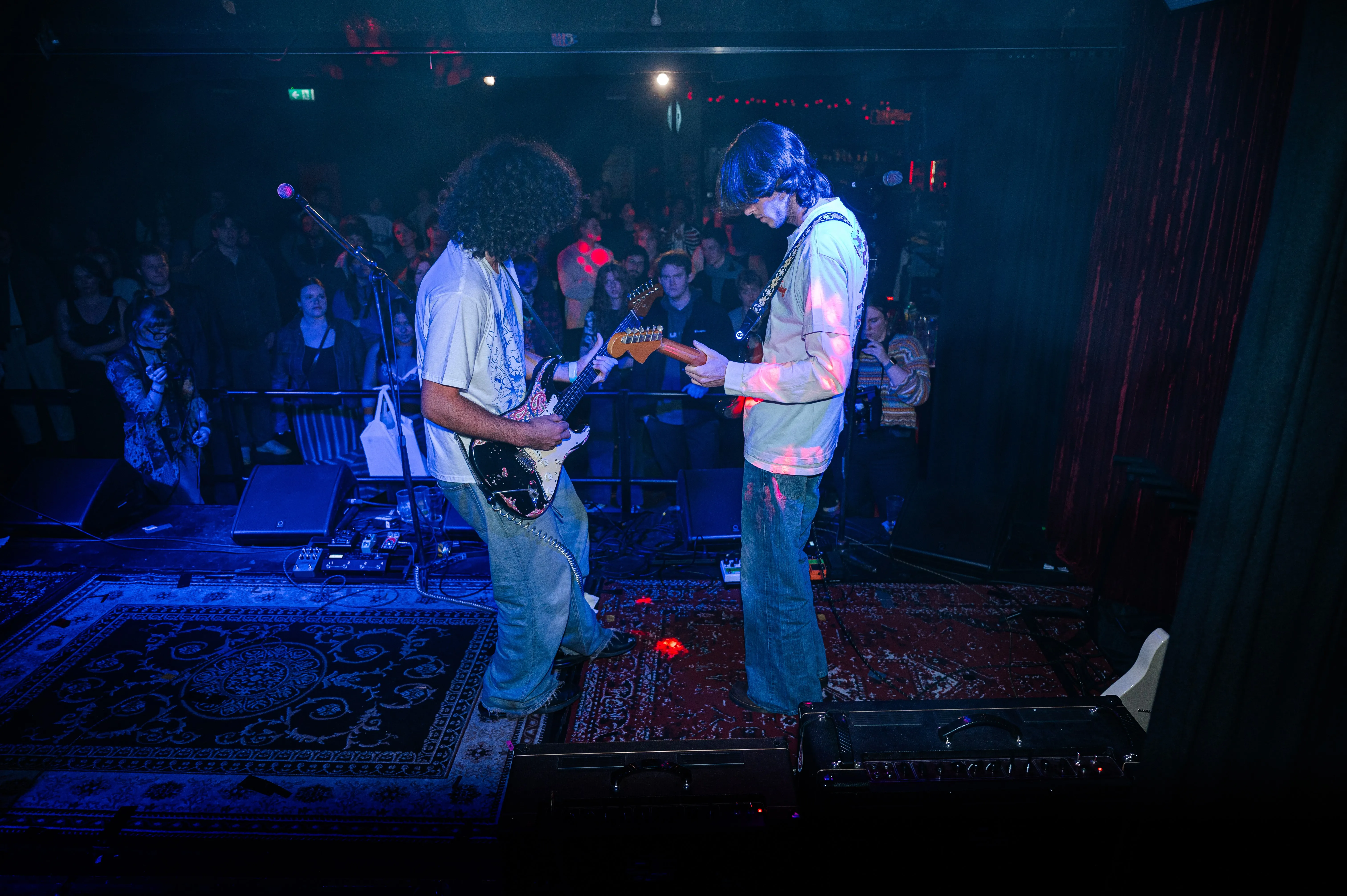 A couple of men standing on top of a stage.