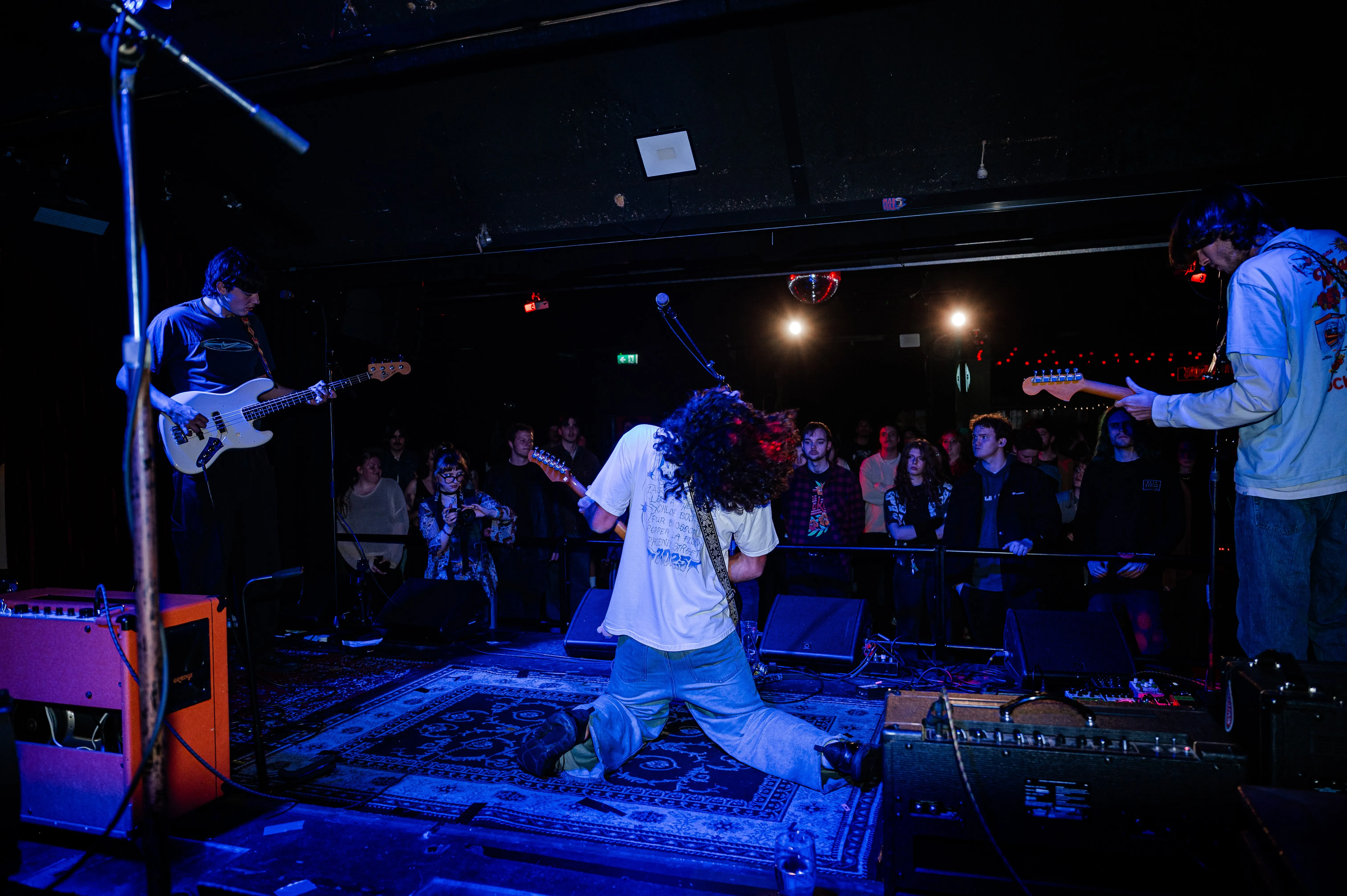 A group of people that are standing in the dark.