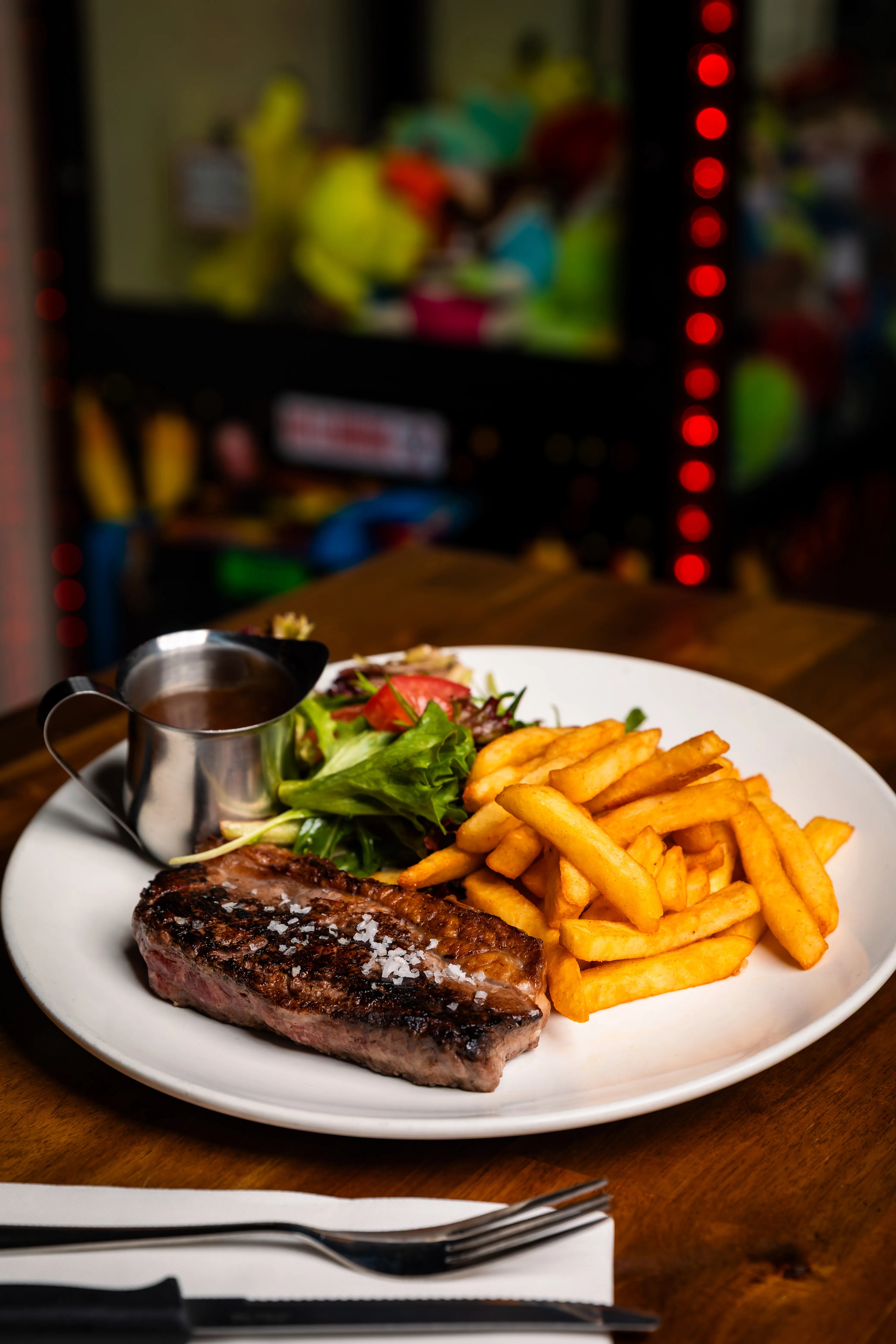 A steak and french fries on a white plate.