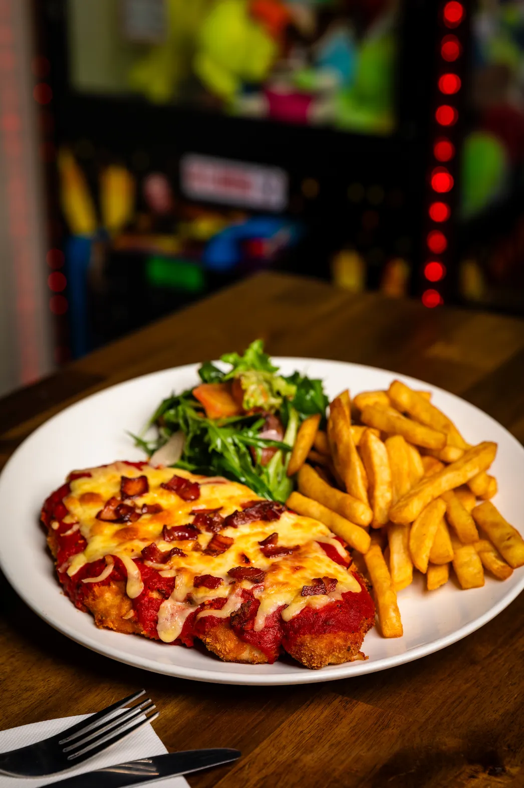 A white plate topped with a cheesy pizza and fries.