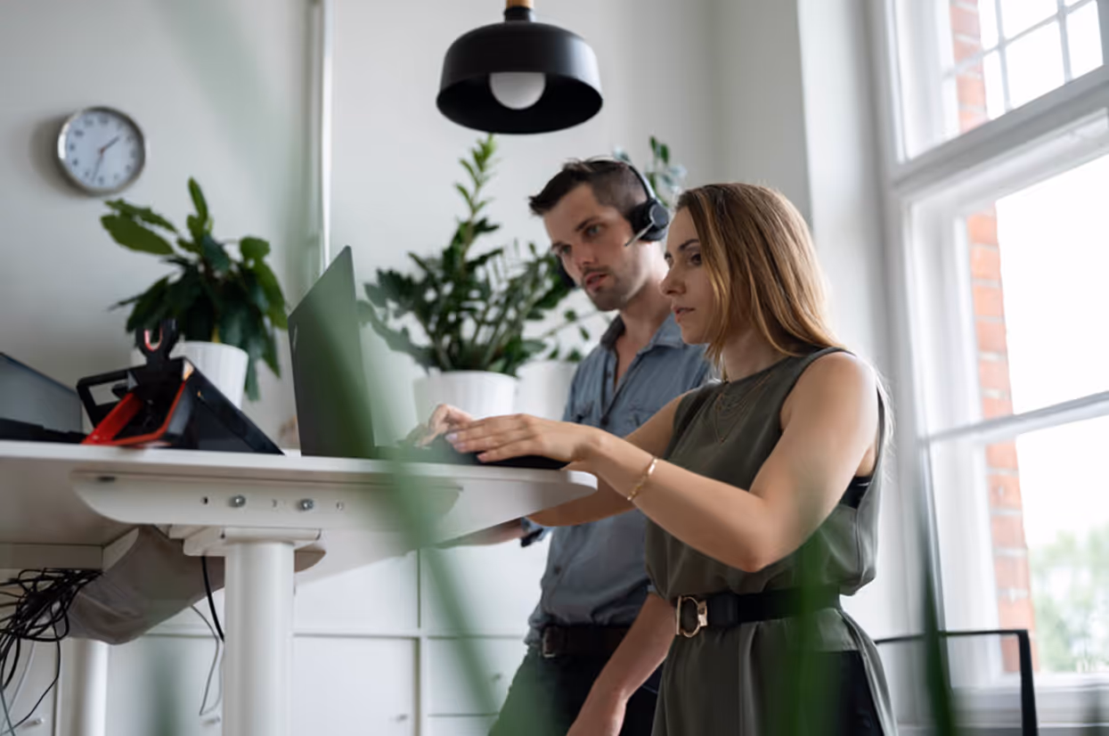 Team members working together at a desk in a bright office