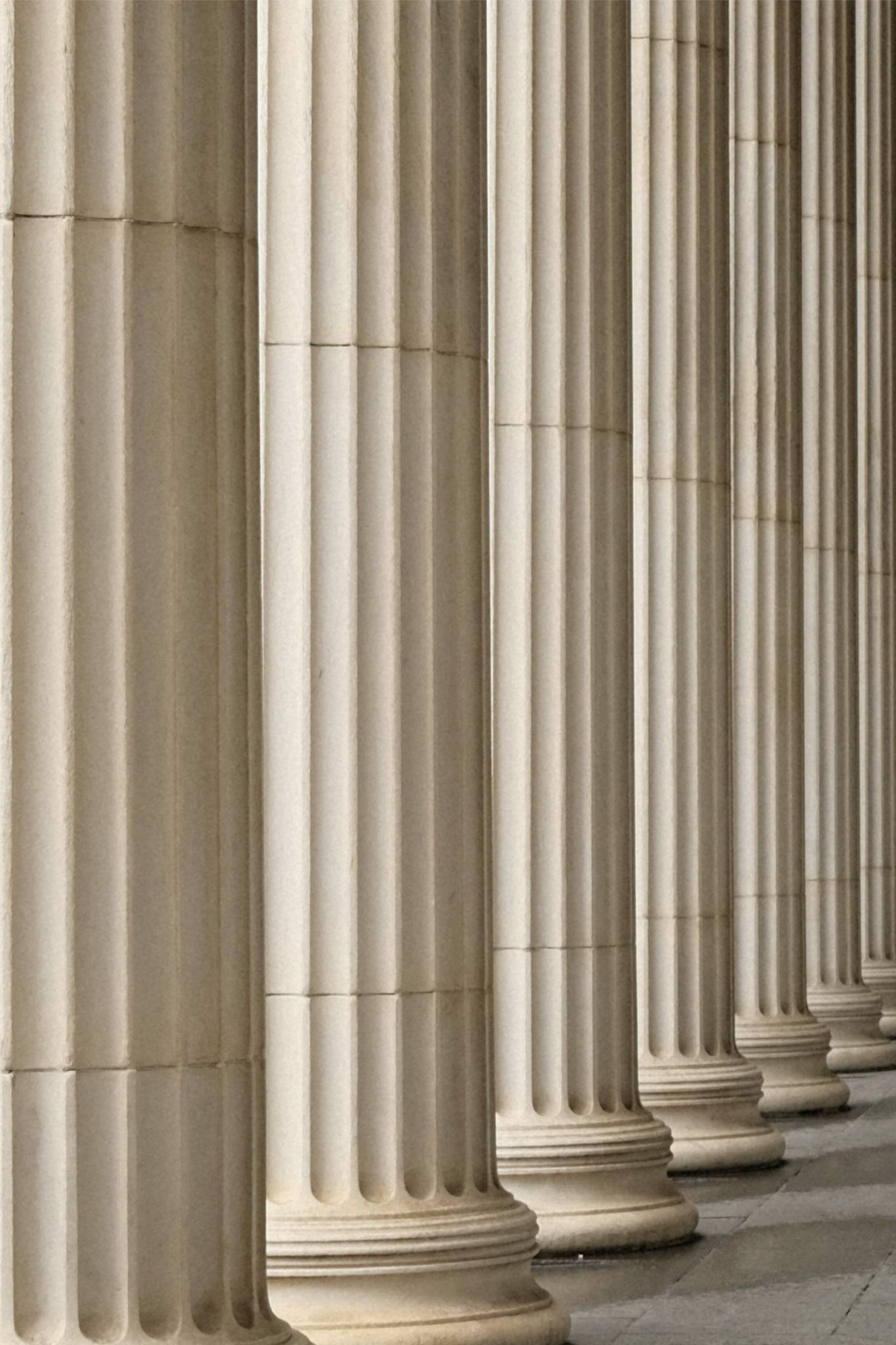 Close-up of a row of large, fluted classical stone columns with rounded bases.