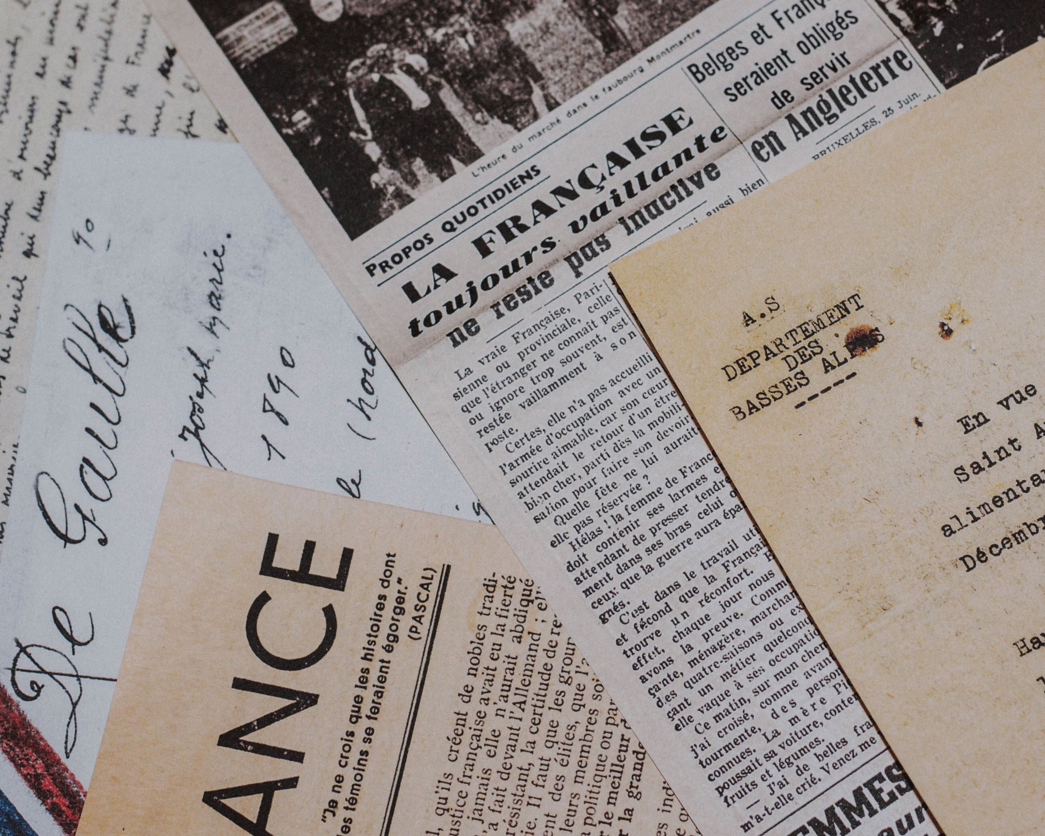 Close-up of vintage French newspapers and handwritten letters with faded text.