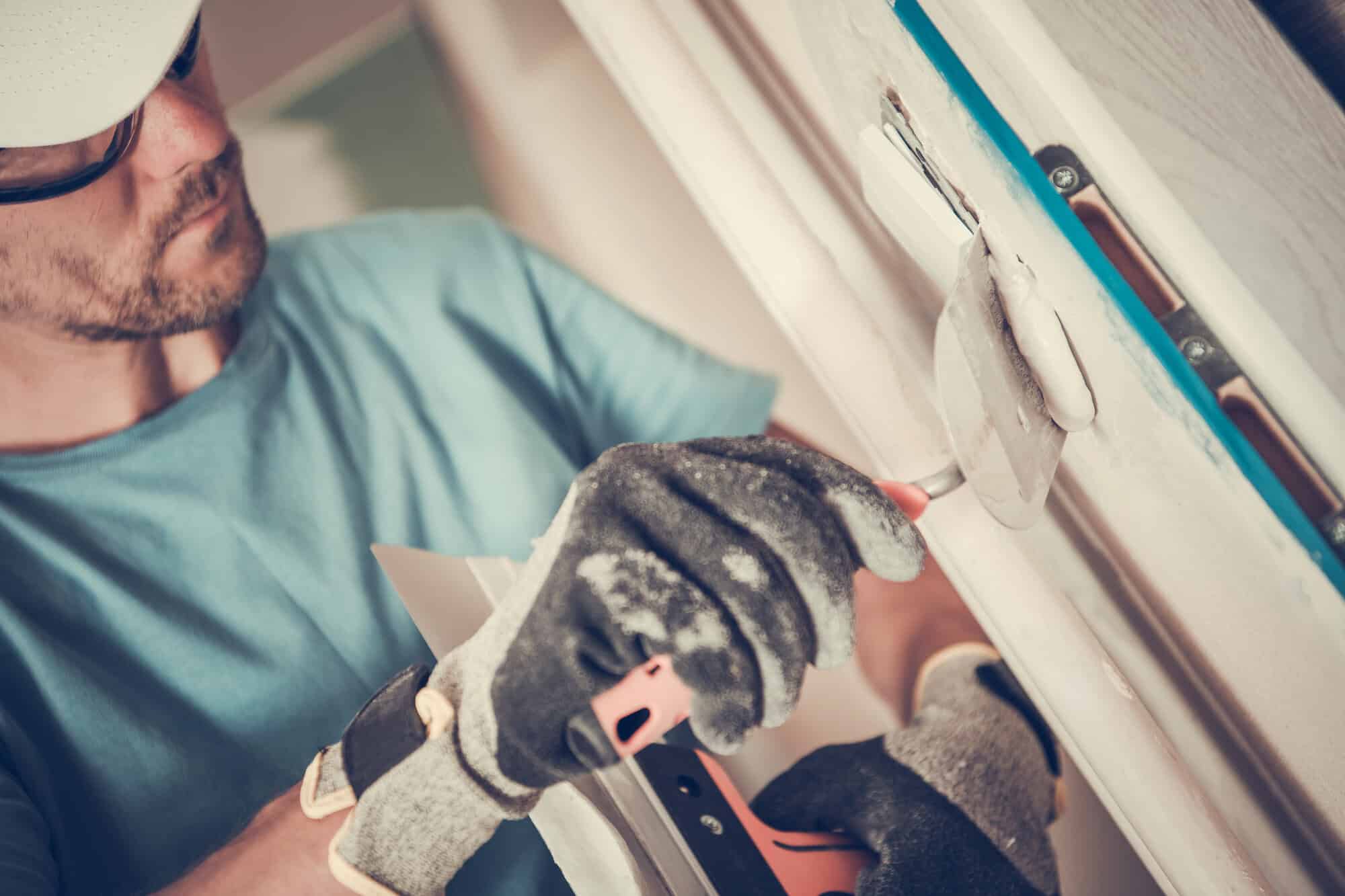 worker applying plaster to wall