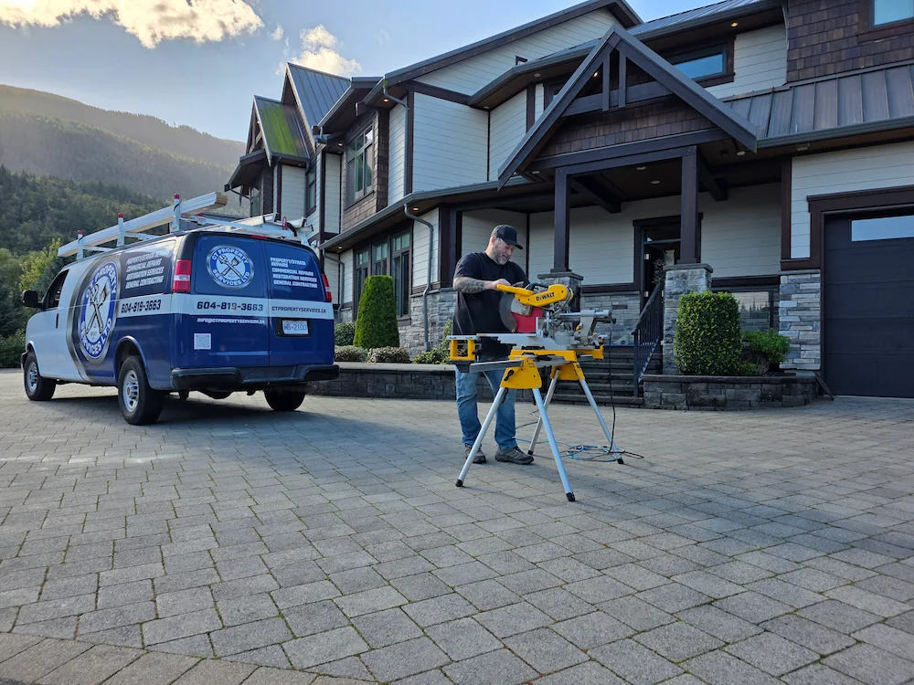 Maintenance worker using table saw on client driveway