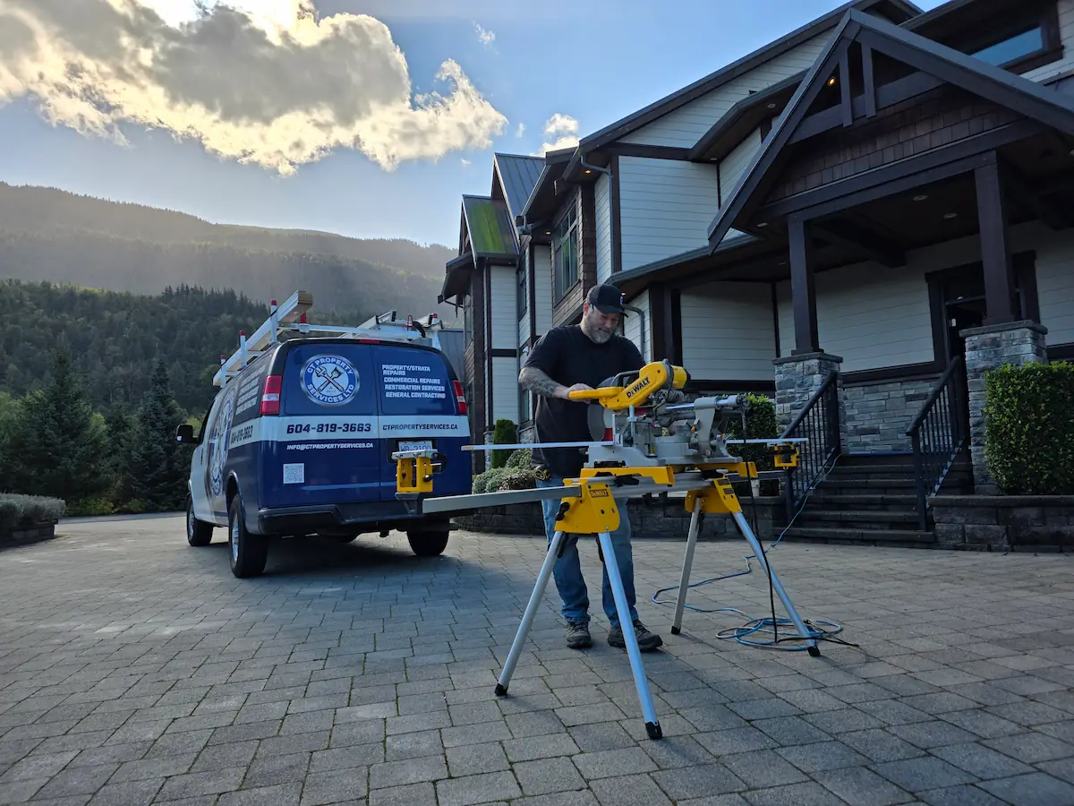 Maintenance worker using table saw on driveway